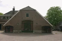 Bakstenen kampboerderij met groene deuren