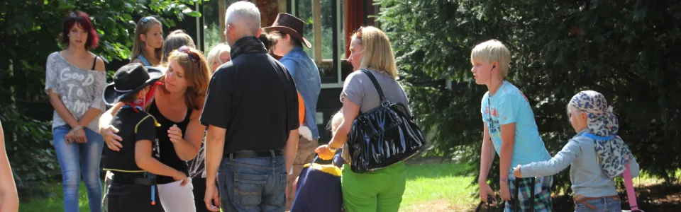 Ouders nemen warm afscheid van hun kinderen bij het kampgebouw