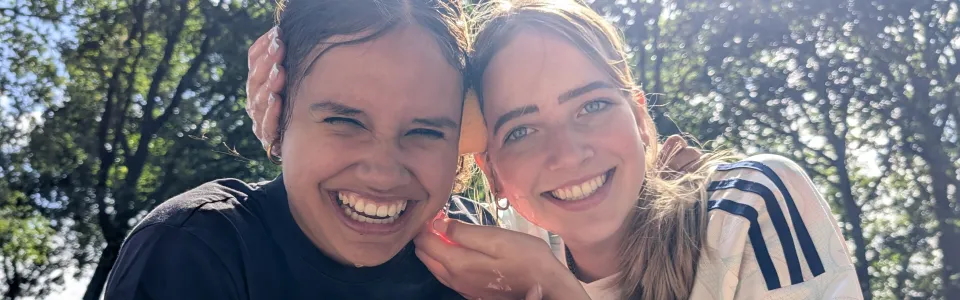 Twee vriendinnen lachen stralend samen in de zomerzon