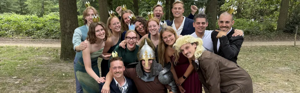 Verklede kampleiding poseert feestelijk met kroontjes in het bos