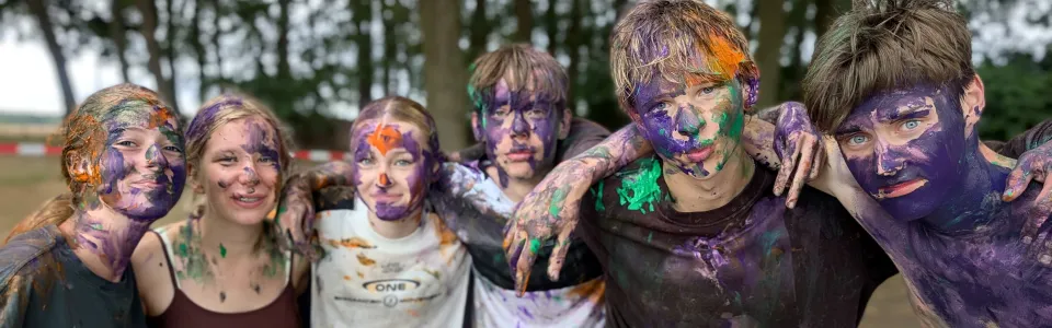 Deelnemers onder de verf poseren samen