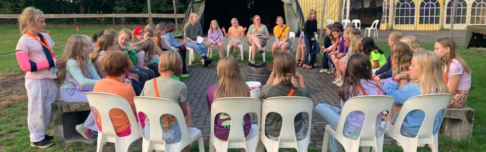 Deelnemers op stoelen voor het podium