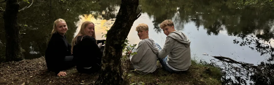 Deelnemers rond een kampvuur in het bos