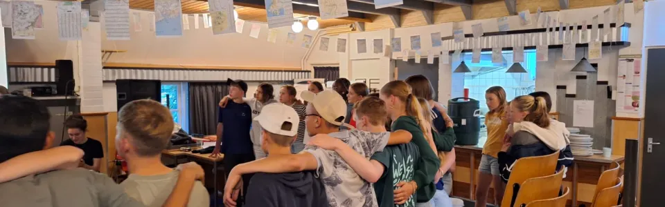 Deelnemers staan in een kring in de zaal