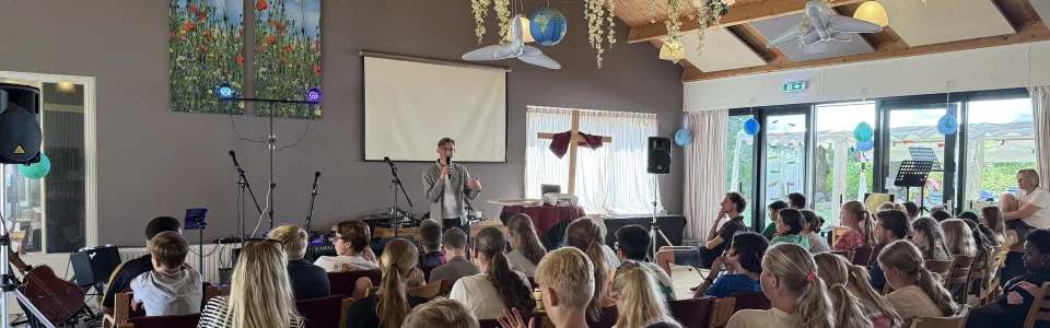 Volle zaal met deelnemers onder papieren slingers