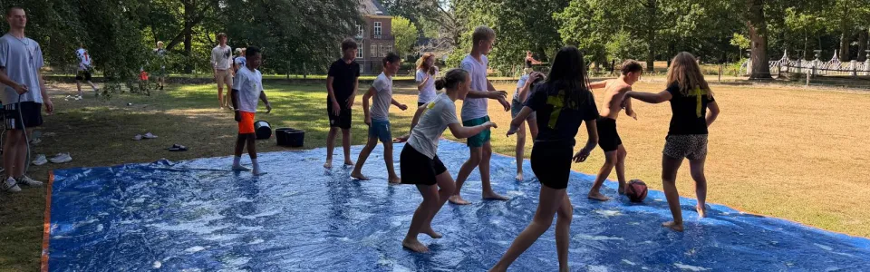 Tieners spelen samen op een zeepgladde mat in het park