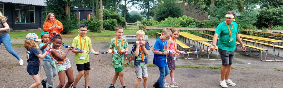 Met alle zorg worden de net gemaakte vlaggetjes vervoerd naar de ochtendprogrammazaal!