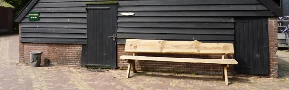 Achterzijde van het groepsverblijf met groot speelgazon aan de bosrand