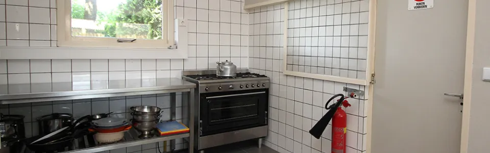 Professionele roestvrijstalen groepskeuken met spoelbakken en werkbladen in De Beuk