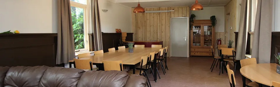 Slaapzaal met stapelbedden en rood-wit geblokt beddengoed in De Beuk