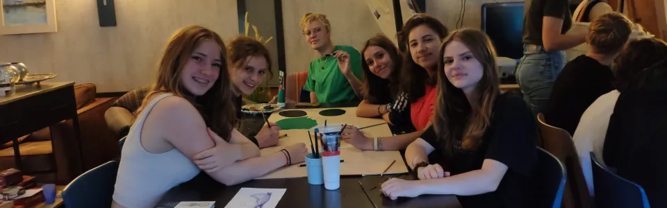Deelnemers zitten aan tafel in de eetzaal