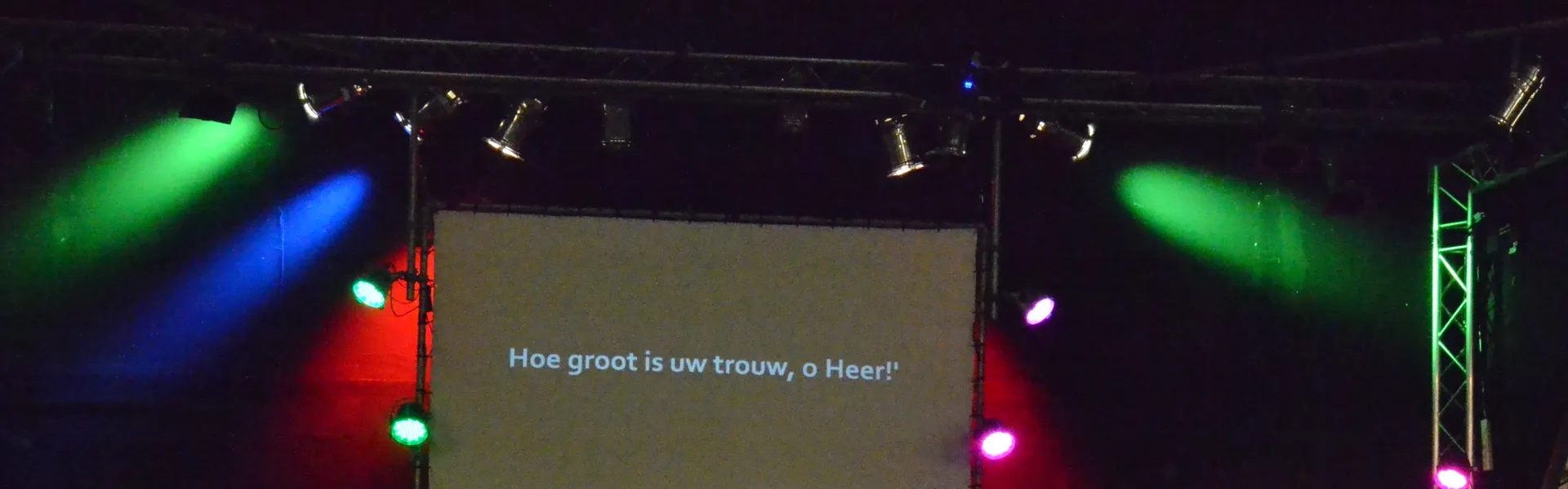 Groepsfoto van de trainingsdag voor een verlicht podium