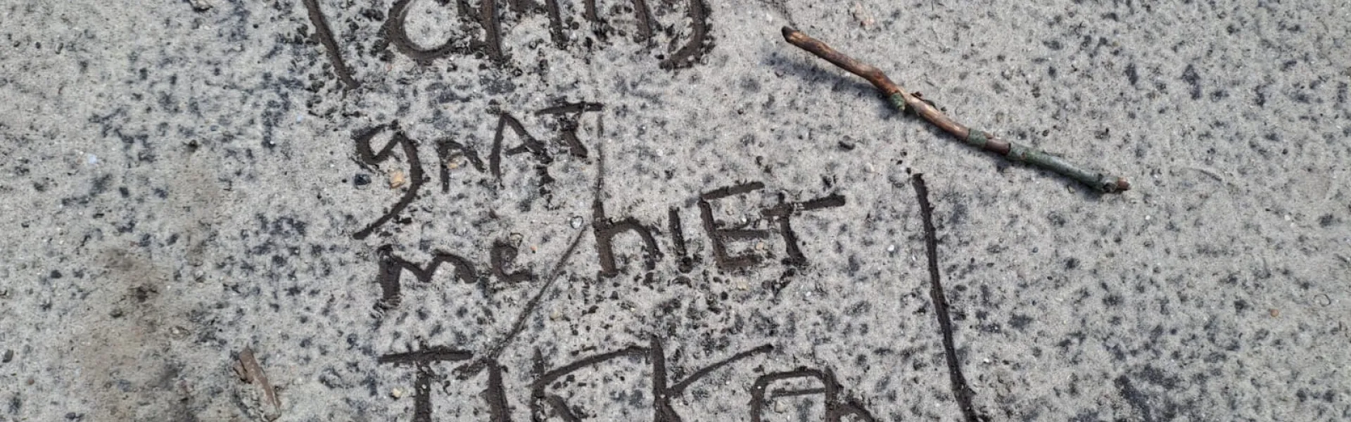Tekst in het zand geschreven met een stok