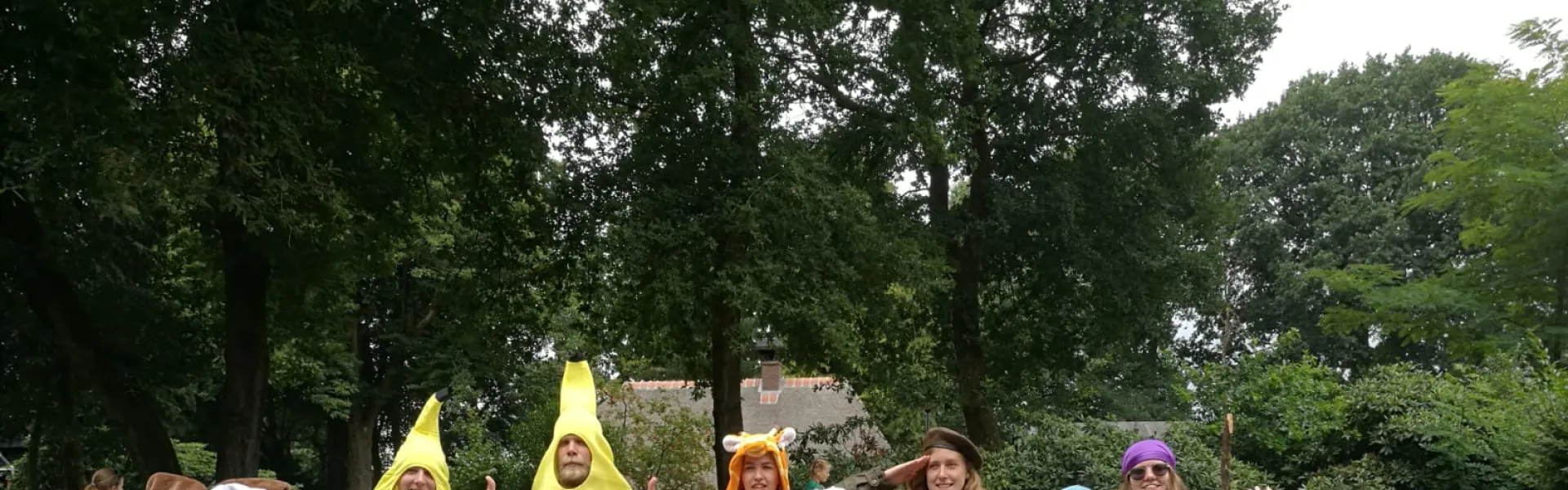 Deelnemers zitten op het gras bij een spel