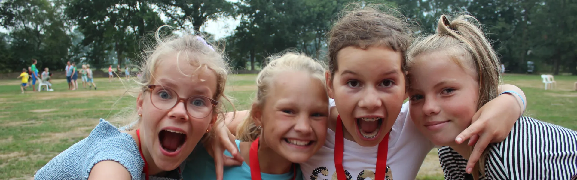 Vier meisjes lachen uitbundig naar de camera